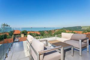 バリートにある44 Horsewood Drive Zimbali Estateのソファとテーブル付きのバルコニーと海