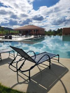 a bench sitting in front of a swimming pool at Pousada Vila Caminito in Brotas