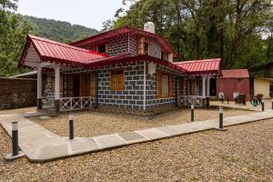 a small house with a red roof at Priory Cottage Heritage Haven in Nainital