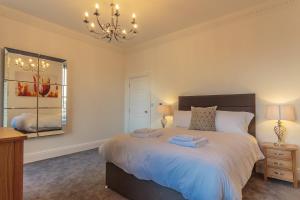 a bedroom with a bed and a chandelier at Luxury 1 bedroom top floor apartment in Plymouth