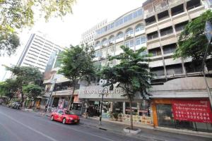 ein rotes Auto, das vor einem Gebäude geparkt ist in der Unterkunft OYO Diamond Residence Silom in Bangkok