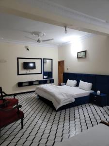a bedroom with a bed and a tv on the wall at Galaxy Hotel Kalam in Kalām