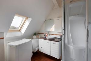 un bagno bianco con lavandino e doccia di Le Ruellan charmant duplex proche plage a Saint Malo