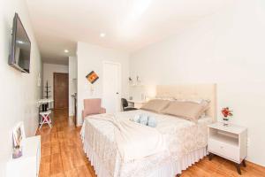 a white bedroom with a bed and a desk at Apto no sudoeste super confortável #212# in Brasilia