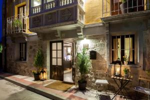 a building with a door and potted plants on a street at Hotel Boutique Valle de Oca in Villanasur-Río de Oca