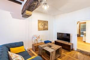 Una sala de estar con un sofá azul y un televisor. en Le Jacobin, appartement de standing - Hyper centre, en Rennes
