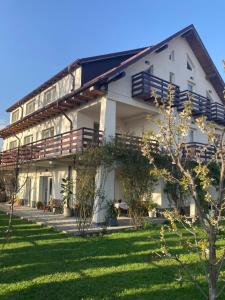 a large white building with a lawn in front of it at Vila Carpatina in Breaza