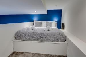 a bedroom with a white bed with a blue wall at 5 Brewhouse by Pureserviced in Plymouth