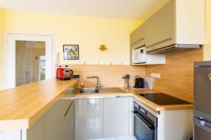 a kitchen with a sink and a wooden counter top at L'Opale - Joli appartement avec jardin et garage in Dinard
