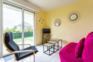 a living room with a red couch and a tv at L'Opale - Joli appartement avec jardin et garage in Dinard