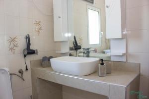 a bathroom with a white sink and a mirror at Emily's Home in Epanomi +30 photos