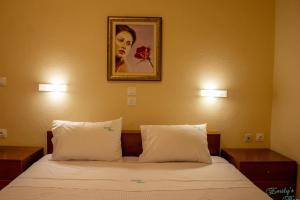 a bedroom with a bed with two pillows and a picture at Emily's Home in Epanomi