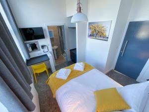 a bedroom with a bed and a yellow chair at 2 bed apartment close to station and city centre in Plymouth