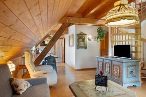 a living room with a couch and a tv at Gasthaus Heiligenbrunnen in Titisee-Neustadt