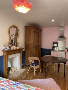 a living room with a table and a fireplace at Studio cocon centre historique in Dinan