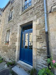 a blue door on the side of a brick building at Studio cocon centre historique in Dinan