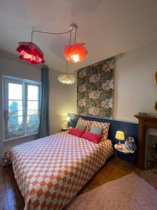 a bedroom with a bed with two red pillows at Studio cocon centre historique in Dinan