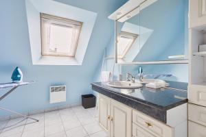 a bathroom with a sink and a mirror at Ker Lys - Grande maison avec 4 chambres et jardin in Dinard +17 photos