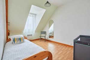 a bedroom with a bed and a chair in it at Ker Lys - Grande maison avec 4 chambres et jardin in Dinard
