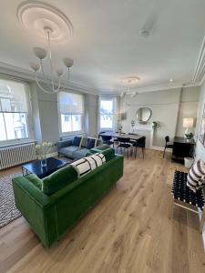 a living room with a green couch and a table at Edenhurst By Pureserviced in Plymouth