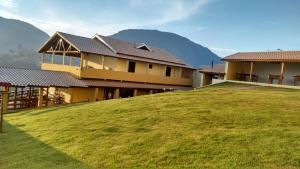 a house on top of a hill with a green field at Pousada Caminho de Minas in Bocaina de Minas