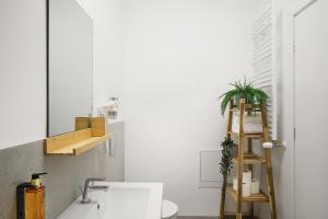 Un baño con lavabo y escalera de madera. en Silk District Apartments, en Iaşi 7 fotos más