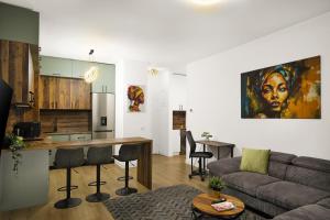 a living room and kitchen with a couch and a table at Silk District Apartments in Iaşi