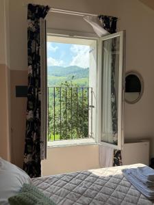 a bedroom with a bed and a window with a view at La Valle degli Amici in Pianello Val Tidone
