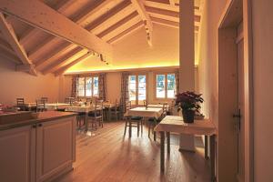 a dining room with tables and chairs and wooden ceilings at B&B Panorama in Gstaad