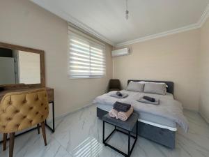 a bedroom with a bed and a mirror and a chair at Villa Royal Sun Elite 29 by MyGuest Cyprus in Iskele