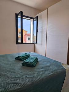 a bedroom with a bed with two green pillows on it at Green Home in Valledoria +3 photos