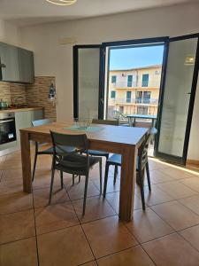 a kitchen with a wooden table and chairs in a room at Green Home in Valledoria