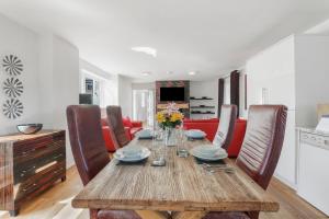 a dining room with a wooden table and chairs at Stable Cottage - North East Escapes in Bamburgh +25 photos