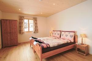 a bedroom with a wooden bed and a window at B&B Panorama in Gstaad