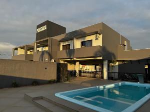 a building with a swimming pool in front of a building at Pousada Barra Coast in Barra Velha