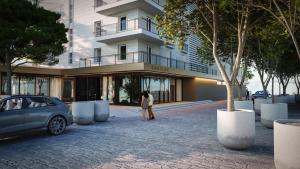 a woman standing in front of a building with a car at Amadria Park Grand Hotel 4 Opatijska Cvijeta in Opatija