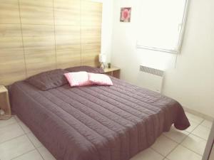 a bedroom with a purple bed with a pink pillow at LE BLEU CAMARGUE - T3 EN DUPLEX CLASSÉ 3 ETOILES - CLIM - ARRIVÉE AUTONOME - Piscine privative à la résidence - Parking Gratuit - Wifi FIBRE - Animaux acceptés - Idéale Famille couple télétravail in Le Grau-du-Roi