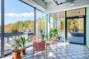 a room with a table and chairs and windows at SHED Coliving studio in Vilnius