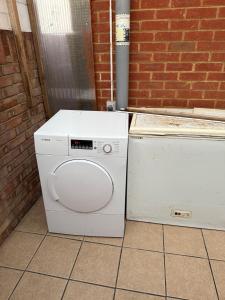 a washer and dryer sitting next to a brick wall at 2 bed-Sleeps 4-Private Patio-Pets-Near Heathrow in Hounslow