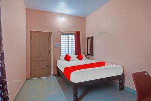 a bedroom with a bed with red pillows on it at Hotel O New Mayuri Lodge in Bāgepalli