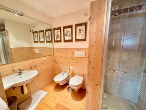 a bathroom with a toilet and a sink and a shower at Esperienza Unica al Passo Giau - Appartamento con Vista Panoramica in Colle Santa Lucia