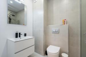Un baño blanco con inodoro y lavabo. en High-end Studio with Panoramic View, Parking & Pool, en Bucarest 29 fotos más