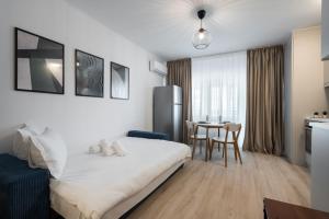 Un dormitorio con una cama y una mesa con sillas. en High-end Studio with Panoramic View, Parking & Pool, en Bucarest