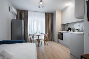 1 dormitorio con cocina y mesa con sillas en High-end Studio with Panoramic View, Parking & Pool, en Bucarest