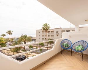 a balcony with two chairs and a view of the city at Modern 1BR Ocean View with AC and Pool in Costa Adeje by Aqua Vista Tenerife in Adeje