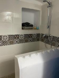a white bathroom with a shower and a tub at Riad Houch Amine B&B in Midoun