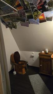 a bathroom with a toilet and photos on the ceiling at Vinds Våningen in Uddevalla