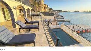 eine Terrasse mit Stühlen und einem Pool neben dem Wasser in der Unterkunft BEST Riverfront Parker Home in Parker