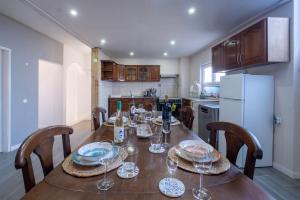 a kitchen with a wooden table with wine glasses on it at Casa Pinheiro in Pinheiro de Coja