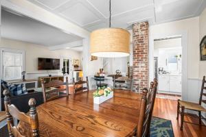 a dining room and living room with a wooden table at Historic Seaside Downtown Mystic Home Walk to Seaport in Stonington